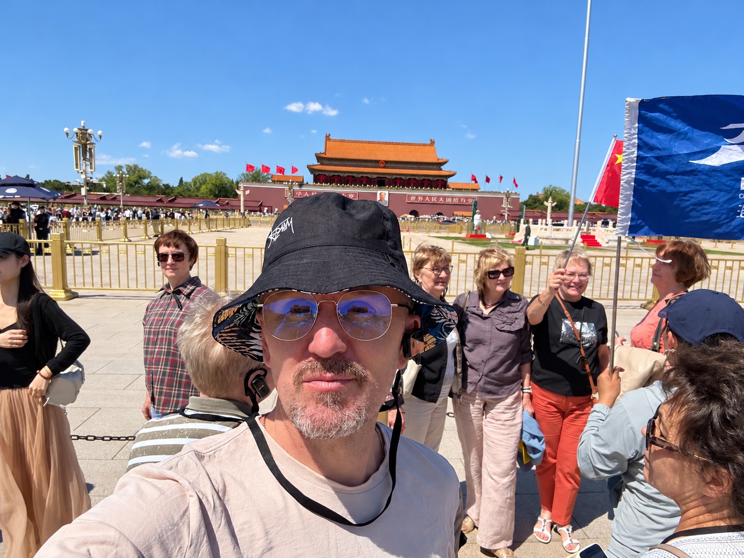 晴天下的广场合影，周围有游客。